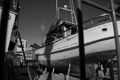 Boats moored at harbor against clear sky