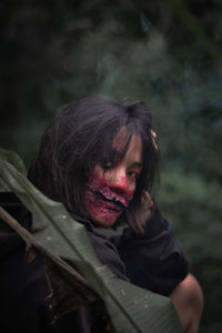 Portrait of young woman with spooky face paint during halloween