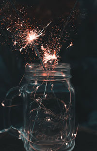 Close-up of illuminated sparklers in mason jar