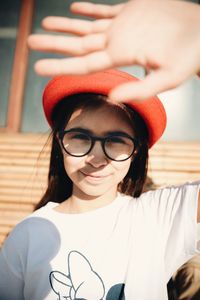 Portrait of teenage girl shielding eyes during sunny day