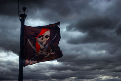 Low angle view of flag against cloudy sky