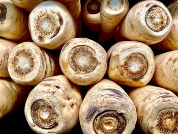 Stacked ends of root vegetables parsnips in market 