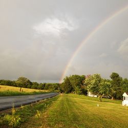 Scenic view of rainbow over landscape against sky