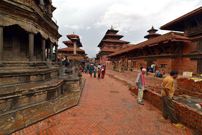 People walking in temple against sky