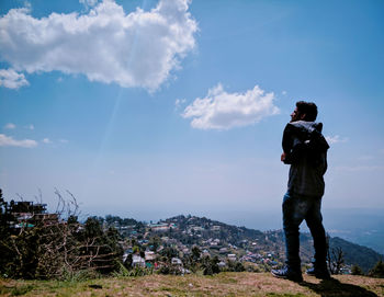 Rear view of man looking at mountain against sky