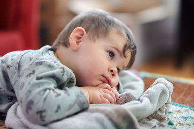 Portrait of a cute young boy watching tv whith his safety blanket