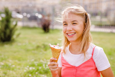 Portrait of smiling young woman holding ice cream