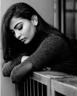 Thoughtful young woman leaning on railing