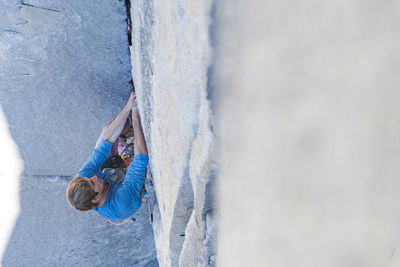 Climber lead climbing changing corners on the nose, yosemite, capitan