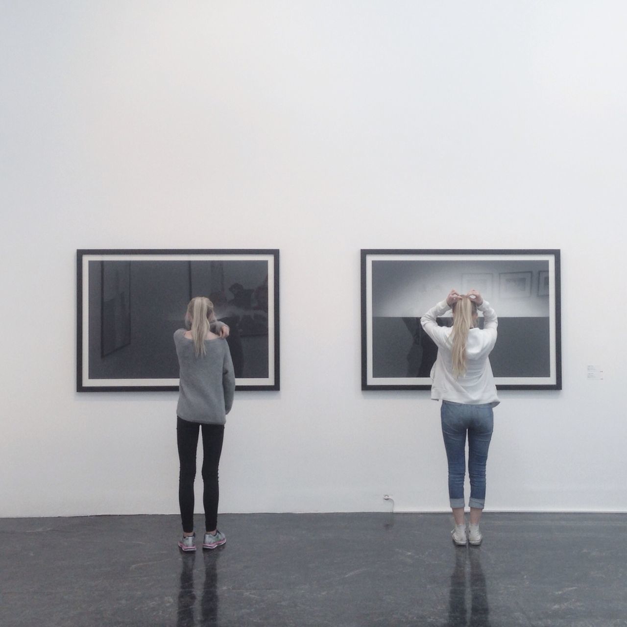 full length, lifestyles, casual clothing, standing, young adult, leisure activity, front view, copy space, rear view, young women, person, three quarter length, wall - building feature, indoors, holding, clear sky, built structure