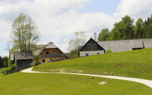 Houses by trees and buildings against sky