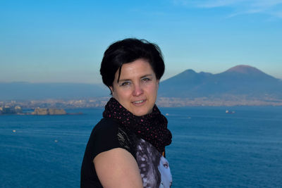 Portrait of smiling young woman in sea against sky