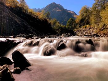 Scenic view of waterfall against sky