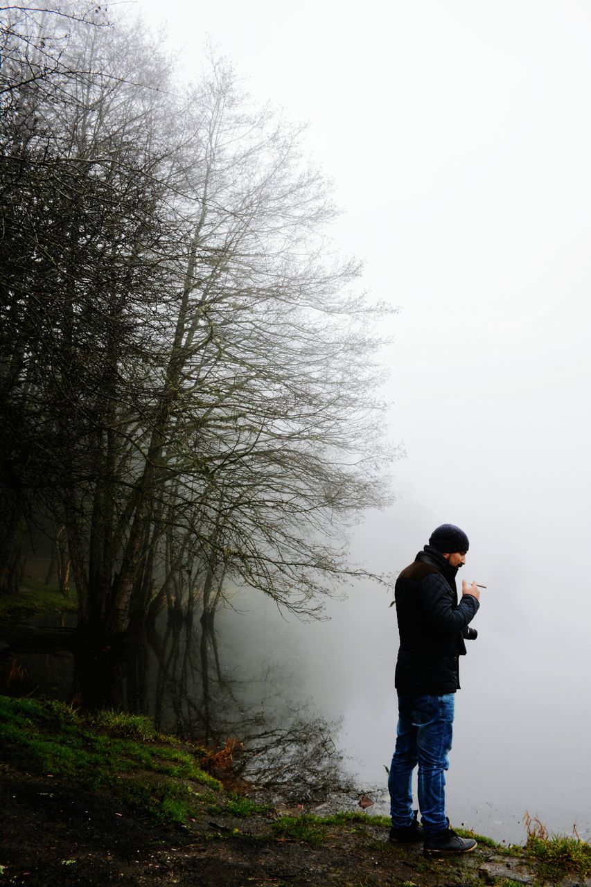 lifestyles, leisure activity, casual clothing, standing, tree, rear view, full length, three quarter length, water, nature, men, clear sky, tranquility, childhood, boys, beauty in nature, tranquil scene, day