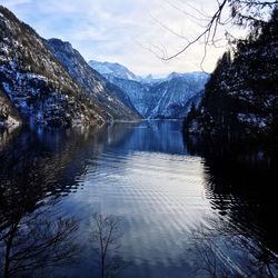 Scenic view of lake by mountains against sky