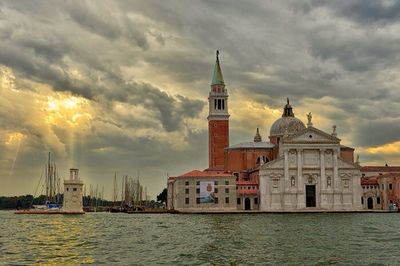 Built structure in water against cloudy sky