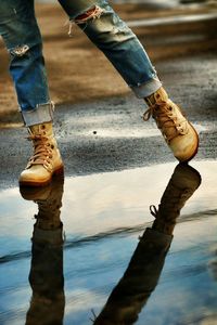 Low section of man standing on puddle