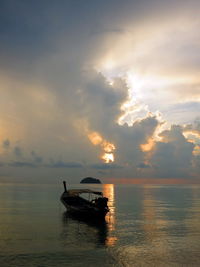 Silhouette boat in sea against sky during sunset