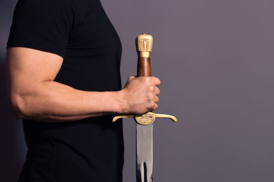 Close-up of man holding hand against black background