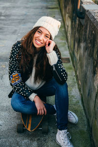 Portrait of smiling young woman sitting in park