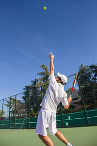 Man playing tennis on court
