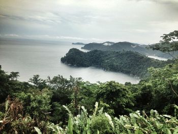 Idyllic shot of sea and mountains against sky