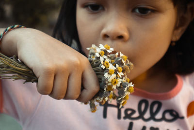 Close-up of woman holding flowering plant