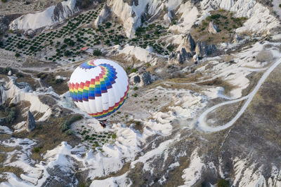 High angle view of hot air balloon over rock formations at cappadocia