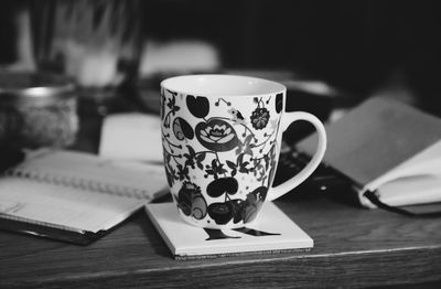 Close-up of mug on book at table