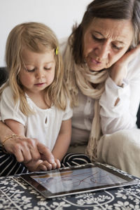 Grandmother with granddaughter using laptop