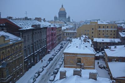 Snow covered cityscape against sky