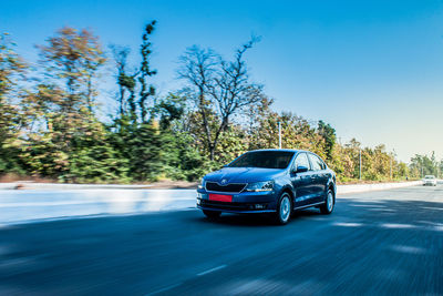 Cars on road against blue sky