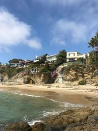 Buildings by sea against sky