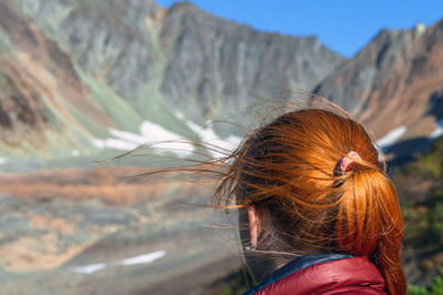 Redhead woman against mountain
