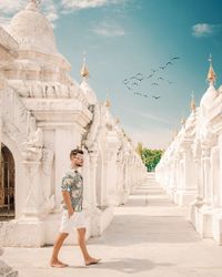 Side view of handsome man walking by stupa