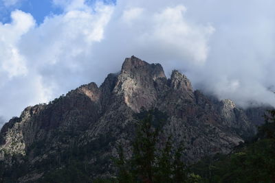 Low angle view of rocky mountain against sky