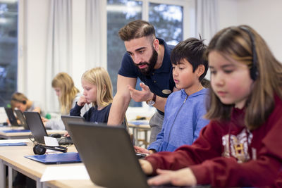 Teacher with schoolboy in classroom