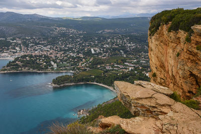 High angle view of city by sea against sky