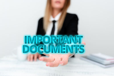 Close-up of woman holding text against white background