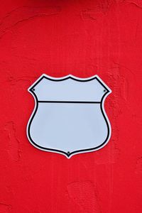 Close-up of arrow sign on red wall