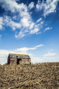Abandoned farmhouse in field