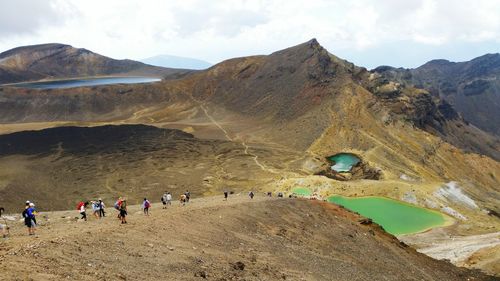 Scenic view of people on mountain against sky