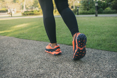 Low section of woman wearing shoes on grass