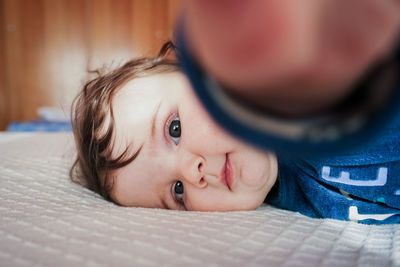 Portrait of cute girl lying on bed at home