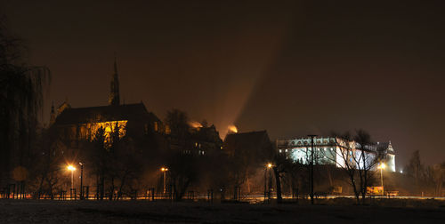 Illuminated built structure against sky at night