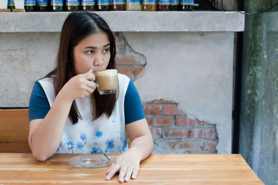 Portrait of young woman drinking coffee