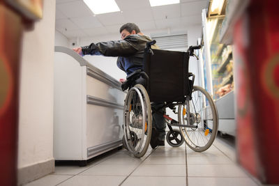 A disabled person in a wheelchair buys groceries