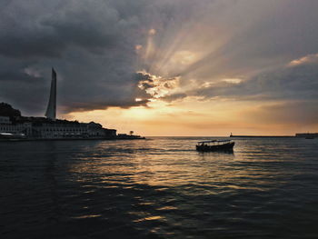 Scenic view of sea against dramatic sky during sunset