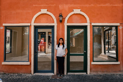 Portrait of man standing against building