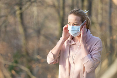 Woman wearing mask standing at park